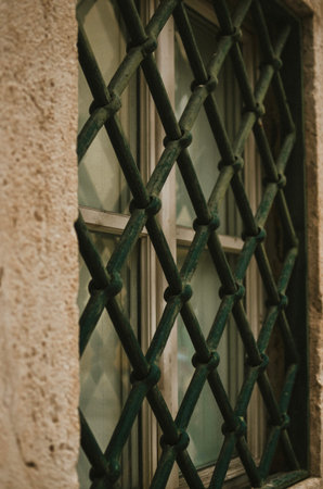 Old antique green lattice on the window of a building in the center of Trogir in Croatiaの写真素材