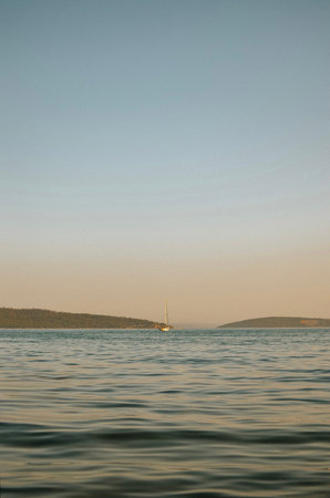 Adriatic sea with sailing yachts and mountains in the background on a sunny summer day in Croatia