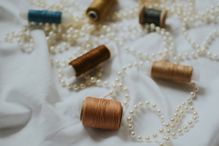 large number of beige and other colors balls of thread on white beads with white backgroundの写真素材