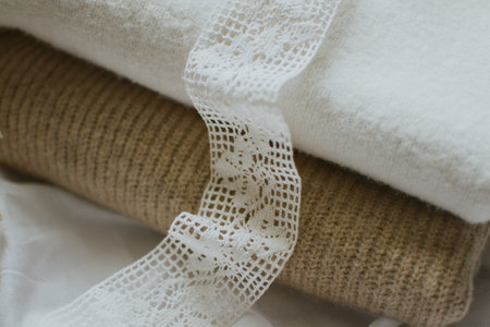 white patterned fabric ribbon on a background of delicate colors of different knittingの写真素材