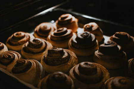 Cooked cinnamon rolls close-up on a baking sheet in the oven for cafe bakingの写真素材