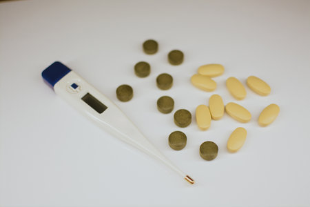 Multi-colored tablets with a medicinal effect and a thermometer for measuring temperatureの写真素材