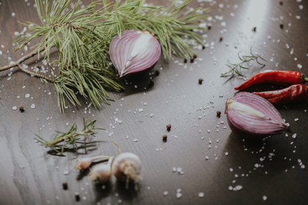 Coarse pepper with salt, garlic, red onion, red pepper and rosemary for the chef to prepare the dish. Close-up on a brown background. High quality photoの写真素材