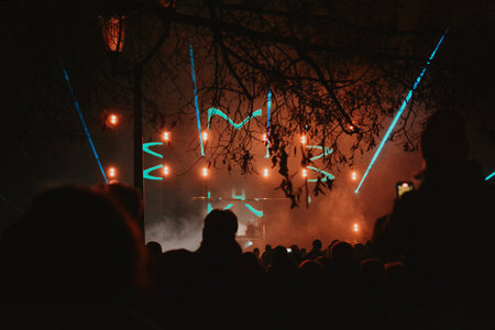 Street concert of a musician in the evening on stage with multi-colored spotlights and a large audience. High quality photoの写真素材