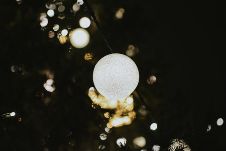 Gold Christmas tree decorations close-up on a spruce with a garland and with gifts for Xmas. High quality photoの写真素材