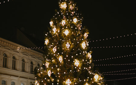 Gold Christmas tree decorations close-up on a street tree with a garland in the Christmas market in the evening. High quality photoの写真素材