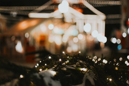 Wrapped garland with lights close-up against the background of a Christmas market in the evening. High quality photoの写真素材