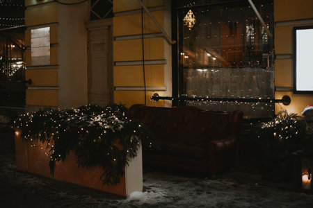 Wrapped garland with lights close-up against the background of a restairant and Christmas market in the evening. High quality photoの写真素材