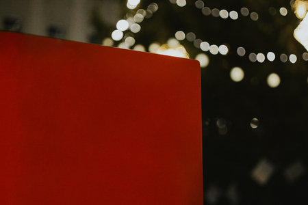 Red empty wall for inscriptions against the background of a Christmas tree with garlands at the fair in the evening. High quality photoの写真素材