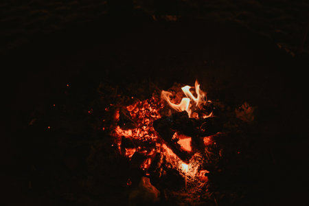 A glowing fire pit with embers and flames, creating a cozy spot for visitors to warm up at a Christmas market. Perfect for themes of warmth, festivity, and seasonal charm. High quality photoの写真素材
