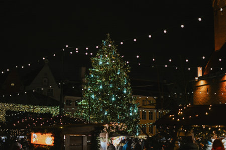 Christmas tree at christmas market at town hall of europe city decorated with lights at night. High...