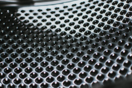 A metallic surface with a textured relief consisting of numerous circular holes.の写真素材