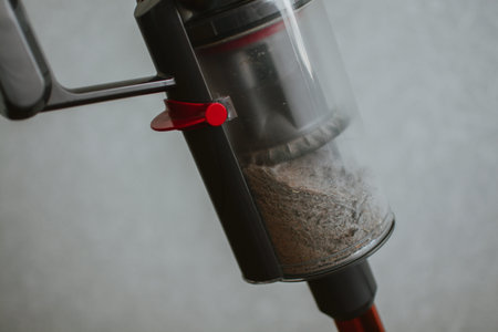 Close-up of a container from a manual vacuum cleaner clogged with dust and dirt after cleaning the...