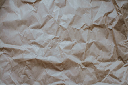 Crumpled eco paper with creases close-up. Textured abstract photo with copy space for text. High...