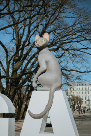 Sculpture of a black cat with yellow eyes from the animated film Flow on the next letters to the Freedom Monument in Riga. RIGA, LATVIA- March 15, 2025.の写真素材