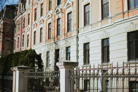 An elegant historic building with a beige neo-Renaissance facade. Rich architectural decoration, arched windows, graceful columns and a balcony, a metal fence. High quality photoの写真素材