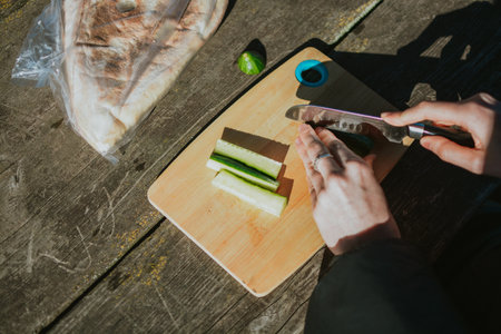 Woman preparing vegetables on cutting board for grilling meat on hike in nature summer close up. High quality photoの写真素材