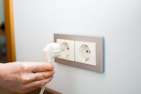 Universal travel adapter in a socket close-up. Adapter for international use of wired equipment...