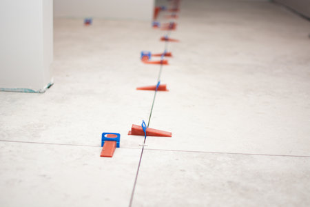 Close-up of ceramic tile installation with tile clips and spacers for grouting. Construction work in a house with building materials. High quality photoの写真素材