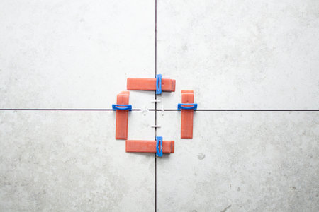 Close-up of ceramic tile installation with tile clips and spacers for grouting. Construction work in a house with building materials. High quality photoの写真素材