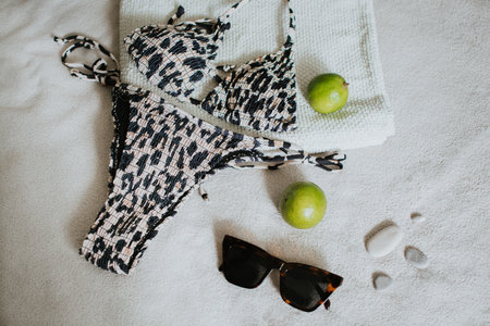 Leopard swimsuit, towel, slippers, glasses and other things for a seaside vacation. Packing a suitcase for a long-awaited vacation. High quality photoの写真素材