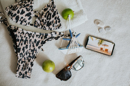 Leopard swimsuit, towel, slippers, glasses, phone screen with a photo of the sea and other things for a seaside vacation. Packing a suitcase for a long-awaited vacation. High quality photoの写真素材