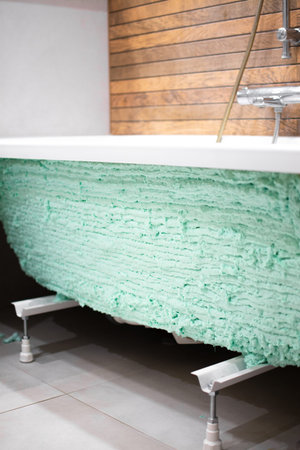 Bathtub covered with construction foam for improved thermal and sound insulation. This method helps...