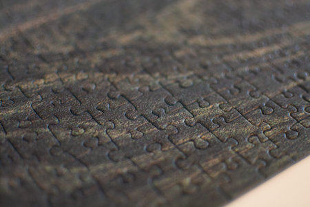 Part of a completed puzzle showing a meadow on a white table, with visible pieces and textureの写真素材