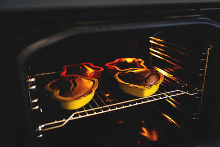 Chocolate Christmas cookies in silicone baking molds are prepared in the oven.の写真素材