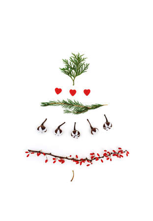 Christmas beautiful and creative Christmas tree on a white background as a symbol of New Year and Merry Christmas made of twigs of thuja, cotton, red hearts and dogwood berries. The concept of an alternative beauty for the holidays.の写真素材