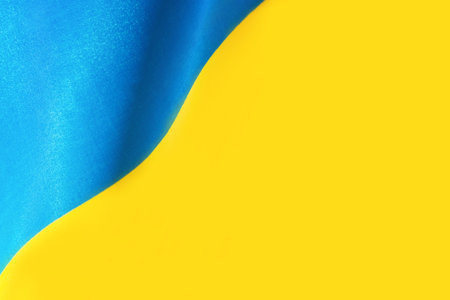 The national yellow and blue flag of Ukraine is painted with a beautiful wave on the fabric....