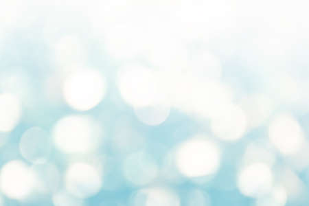 Bright abstract winter defocused background with shimmering sunspots in white and blue. bokeh. Holiday concept festive. Copy space for text.の写真素材