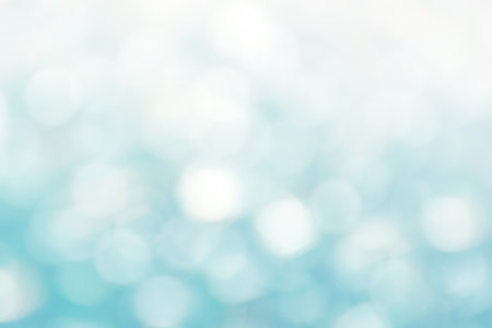 Defocused Bright abstract winter blue background with white shimmering sunspots. Bokeh. Holiday festive concept. Copy space for text. Merry Christmas and Happy New Yearの写真素材