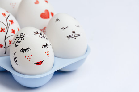 Close up of beautifully painted Easter eggs - gentle beauty with red lips, cats face, hearts and...