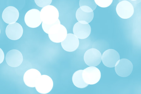 Blue Defocused Bright abstract winter background with white shimmering sunspots. Bokeh. Holiday festive concept. Copy space for text. Merry Christmas and Happy New Yearの写真素材