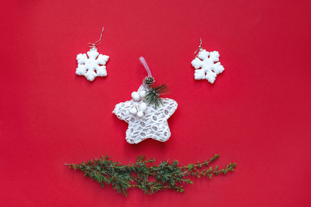 Merry Christmas smile. New Years decorations lie like cheerful face on red background. White snowflake toys and green Christmas tree branch. Happy holidays. Card with Copy Space for text.の写真素材