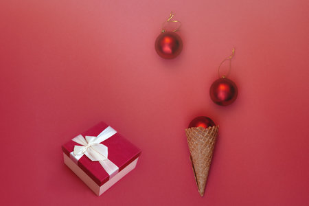 Red Christmas decorations on a Christmas tree branch. round toys. minimalist style. Copy space for text. For advertising or as a ready-made holiday card.の写真素材