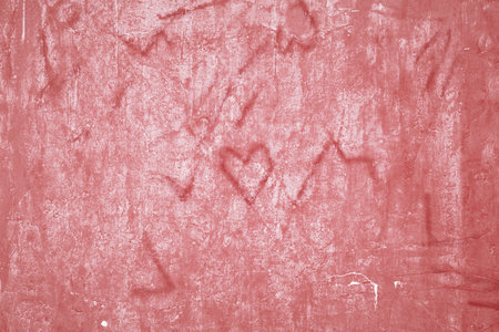 Defocused focus on Grunge beautiful red wall with cracks on plaster with space for text or image. Abstract drawings of hearts, lines and cracks on the background. stylized texture. Happy Valentineの写真素材