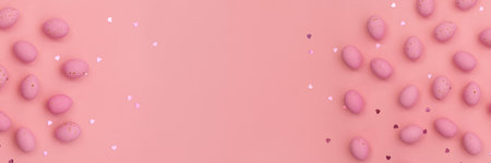 Banner made from Easter pink chocolate eggs on pastel pink background. Shimmering glowing hearts. minimalist composition. Use in marketing materials, decorative element in a variety of contextsの写真素材