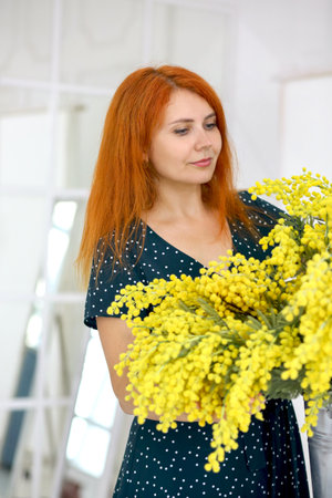 Cute girl with a bouquet of yellow mimosa. Spring. Floristry concept.の写真素材