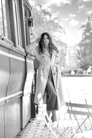 Black and white photo with a girl in a raincoat walking in the autumn park. Autumn. women psychologyの写真素材