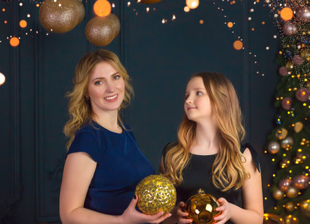 Beautiful mother and daughter in blue dresses on New Year's Eve. Family Holidays conceptの写真素材