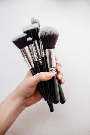 Beautiful brushes for make-up in the hands of a young girl. Isolated.の写真素材
