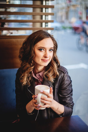 Girl with cappuccino in hands.の写真素材