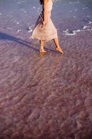 Beautiful girl on a pink lake.の写真素材