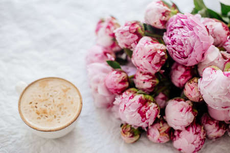 Cup of coffee and a bouquet of peonies.の写真素材