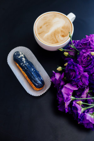Cappuccino, eclairs and flowers.の写真素材