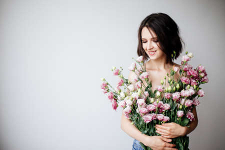 Beautiful girl with a bouquet flowers.の写真素材