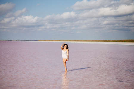 Beautiful girl on a pink lake.の写真素材