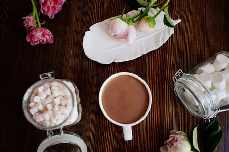 Hot cocoa with marshmallow on a table with peony flowers. Flatlay.の写真素材